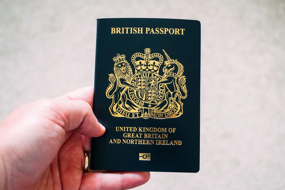 A British passport held in one hand