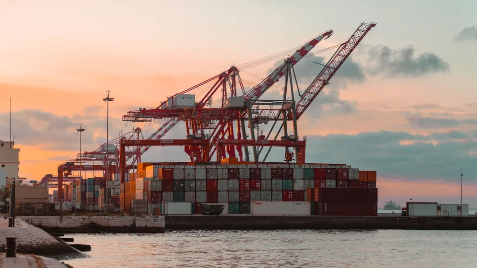 Container cranes at a port at sunset